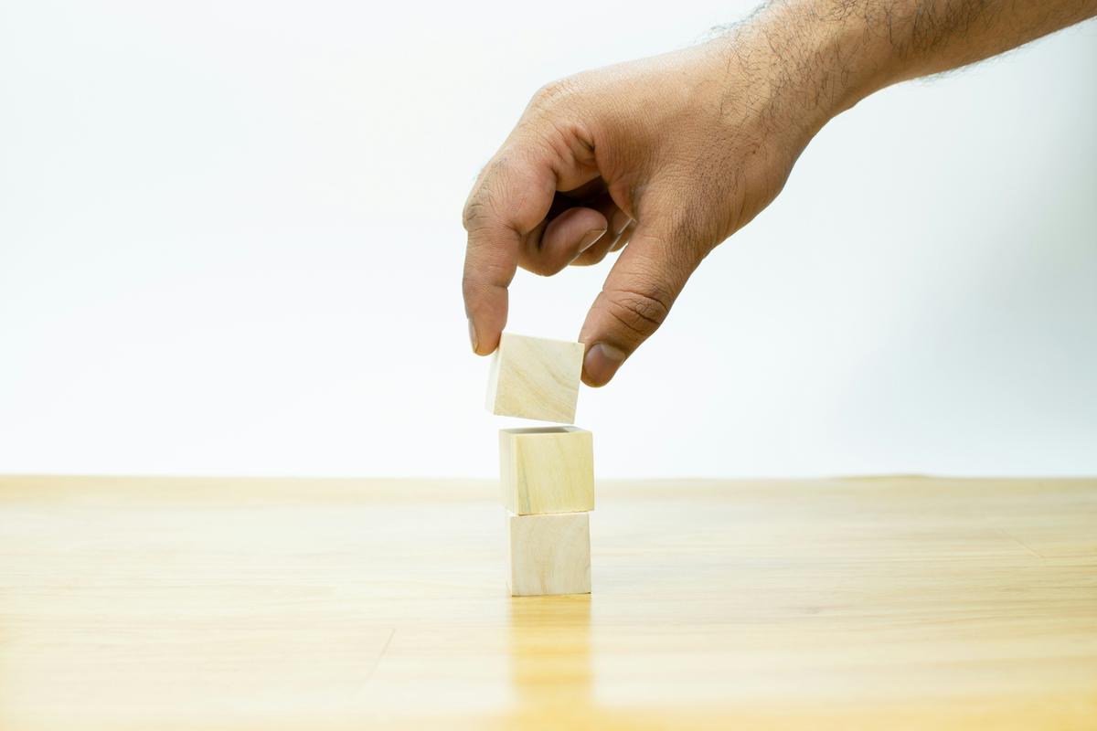 Hand placing wooden blocks